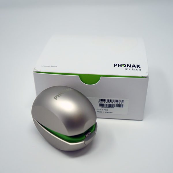 Phonak mini charger champagne colour sat next to white Phonak box on white background