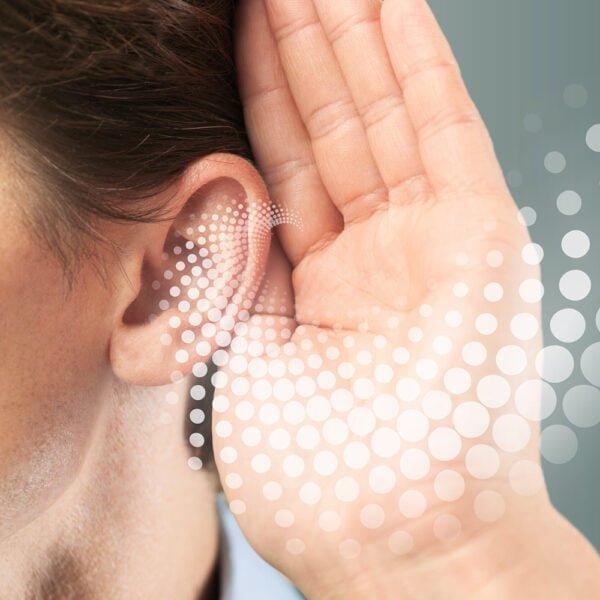 Woman holding her hands near left year showing high frequency hearing loss waves
