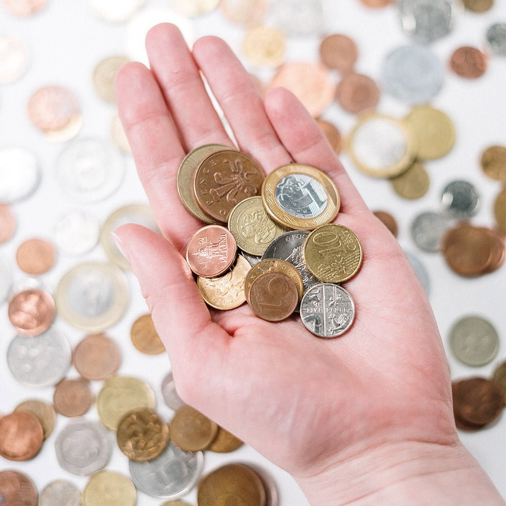 Close shot of a hand holding coins addressing the cost of living crisis