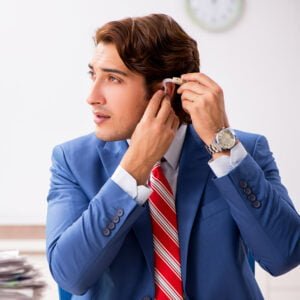 Employee with hearing loss is using hearing aid in office