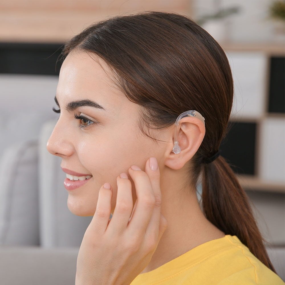 Young woman wearing a hearing aid with hearing aid accessory