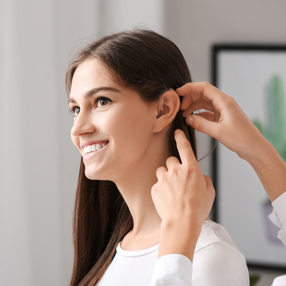 Young woman having a her ears tested for earwax.